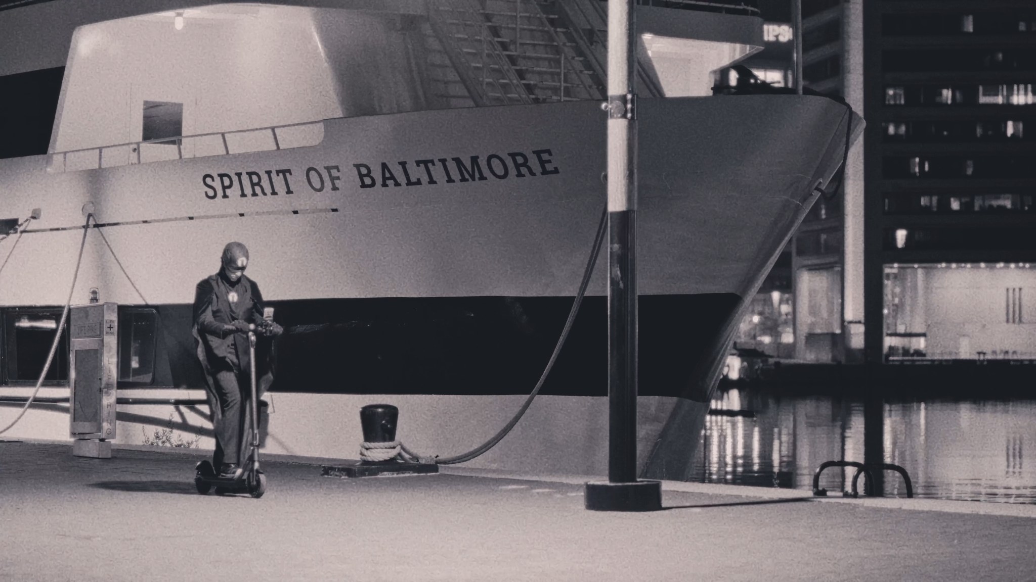The Raven on a scooter beside the Spirit of Baltimore at the Inner Harbor.